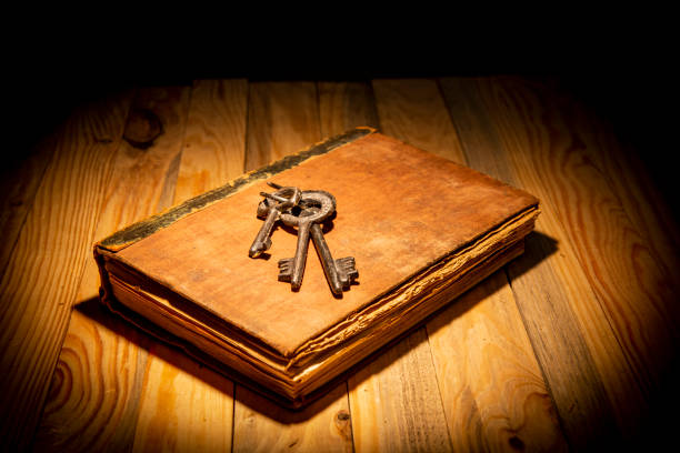 Vintage book with old keys on dark table top - education and knowledge theme