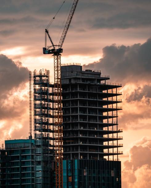 istock Vertical shot of a crane building a skyscraper during a sunset 1438413685
