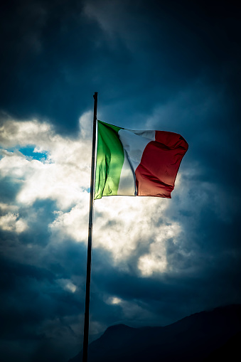 Flag of Italy pictured against stormy sky