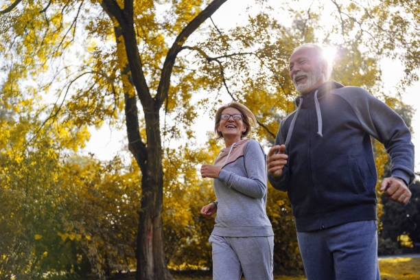 istock Cheerful active senior couple jogging in the park 1438415463