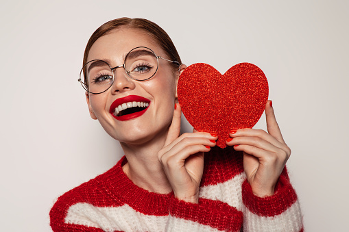 Beautiful emotional woman holding artificial heart