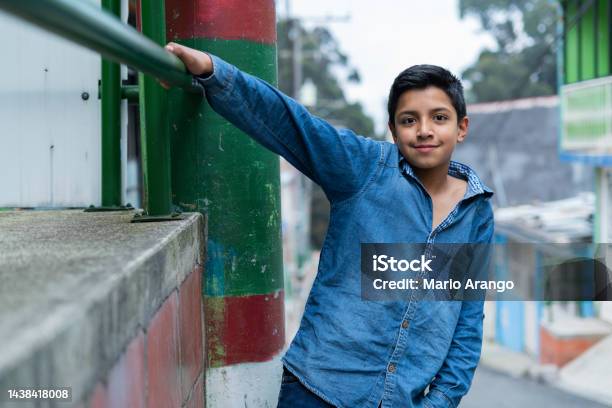 Latin Boy With An Average Age Of 10 Years Old Is On The Street Looking At The Camera That Portrays Him While Smiling Stock Photo - Download Image Now
