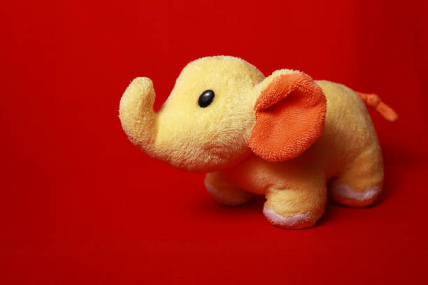 bambola elefante gialla - cose con sfondo rosso - elephant art creativity decoration foto e immagini stock