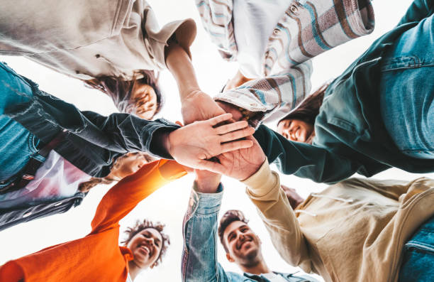 istock Community of young people stacking hands together - Multiracial college students putting their hands on top of each other - Human relationship, social, community and college concept 1438420749