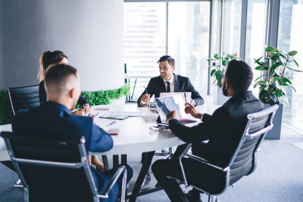 istock Corporate employees sitting at meeting table having conference brainstorming for discussing business ideas and create startup strategy for progressive project, concept of briefing for search solutions 1438421914