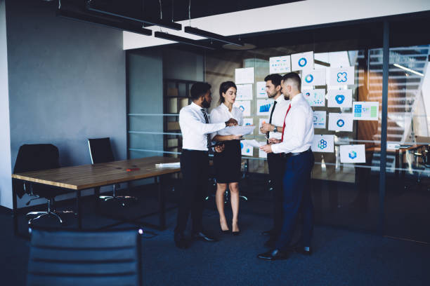 istock Experienced business persons have CEO conversation for brainstorming on revenue charts during work day in corporate office, male and female analysts discussing executive documents while briefing 1438422105
