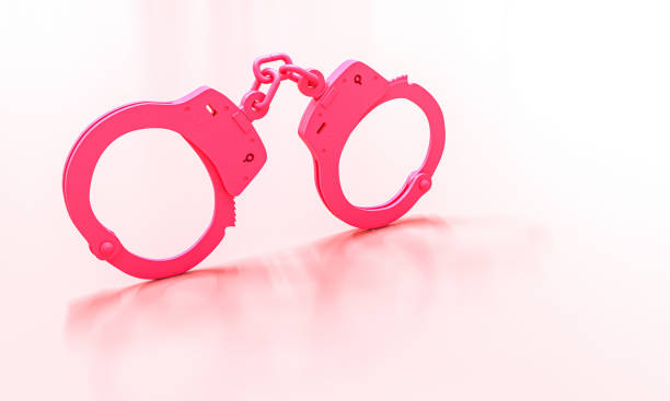 classic pink handcuffs on a light background.