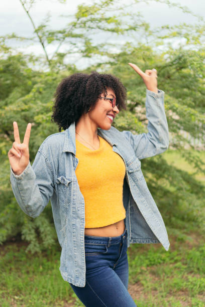 istock Latin woman dancing while standing outdoors on a natural green background. 1438426253