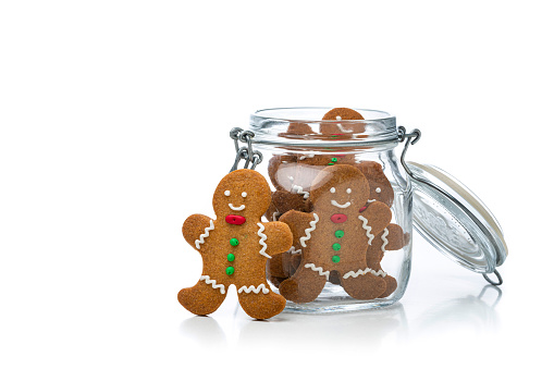 High angle view of gingerbread man cookies jar shot on white background. The composition is at the right of an horizontal frame. High resolution 42Mp studio digital capture taken with Sony A7rII and Sony FE 90mm f2.8 macro G OSS lens