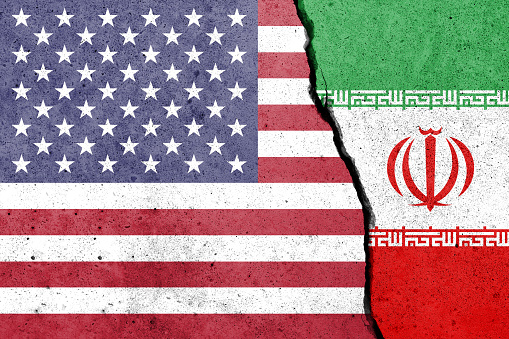 United States of America and Iran flags painted on the concrete wall. USA and Iran conflict