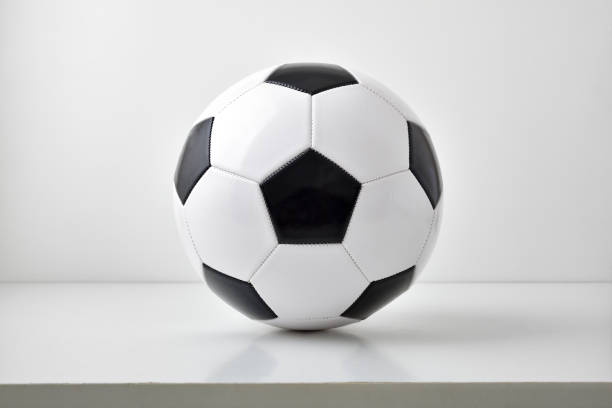 istock Soccer ball centered on table and light gray background 1438434414