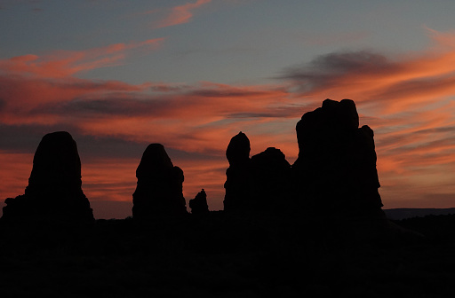 Sandstone towers and pillars silhouetted against the dark remains of sunset. Arches National Park, Utah.