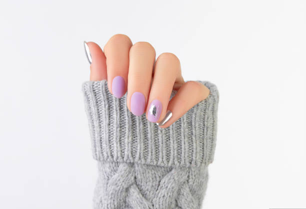 istock Close up womans hand with matte lavender and silver nails in sweater 1438437477