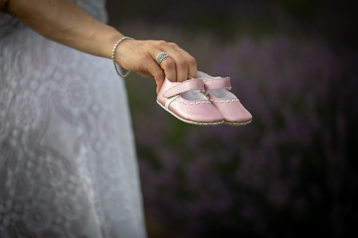 Close up of pink baby shoes in a gender reveal situation. Discovery of a daughter