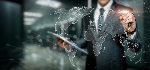 Businessman works in the global network on a world map on a blurred background.