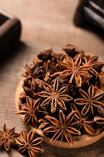 A vertical shot of anise stars on a wooden table