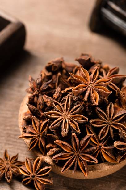 tiro vertical de estrelas de anis em uma mesa de madeira - anise - fotografias e filmes do acervo