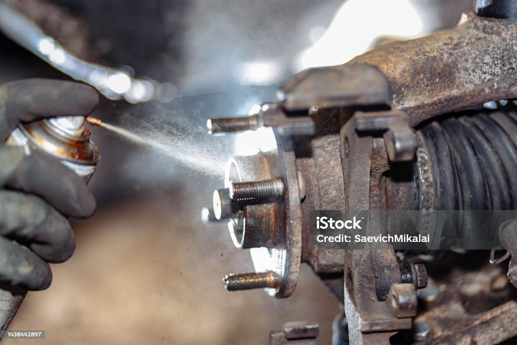 spray lubrication of the wheel hub and vehicle bolts. Silicone, copper graphite grease. Andorra Stock Photo