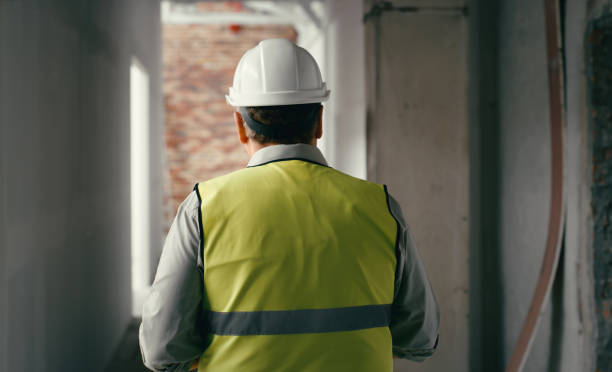 istock Construction, building and design with a man architect walking through a build site in a hardhat and reflective vest. Engineer, creative and designer with a male worker in the architecture industry 1438443068