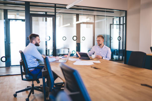 istock Successful male colleagues using laptop and touch pad for making online research and share data talking to each other on meeting table, businessmen discussing partnership strategies in office 1438443271