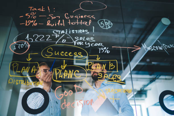 istock Professional male employees looking at infographic and information creating solutions for startup together, 20s young caucasian men business partners discussing data and information on meeting 1438443840