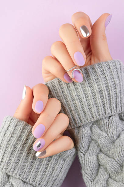 istock Close up womans hands with matte lavender and silver nails in sweater 1438445753