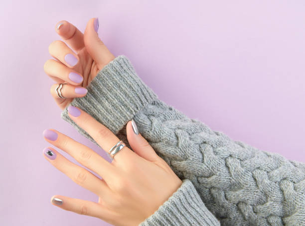 istock Womans hands with matte lavender and silver nails. Beauty treatment 1438445828