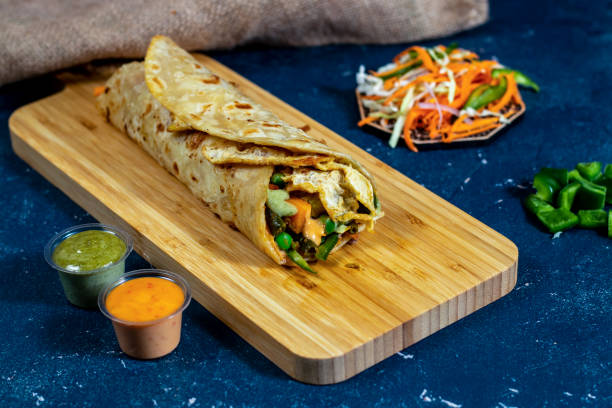 istock egg and Vegetable shawarma wrap with salad dip and sauce isolated wooden board side view of fastfood 1438448371