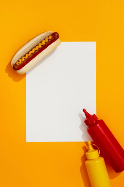istock Classic hot dog with wurst, ketchup and mustard on orange background 1438450188