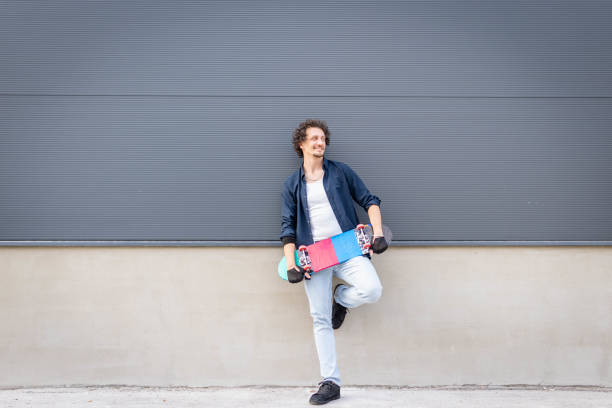 Portrait of a hip man posing with his skateboard