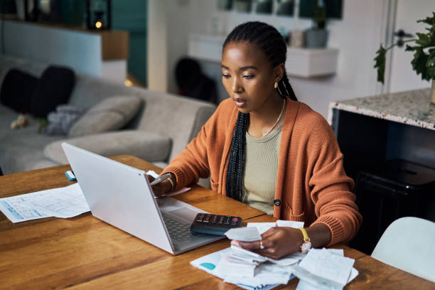 Black woman, budget and home finance on laptop for accounting, money planning and fintech investment. Paper bills, savings and web payment review, online banking and insurance loan of financial taxes stock photo
