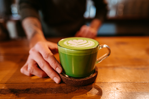 Close-up of a green cup of coffee in a coffee shop for St. Patrick's day.