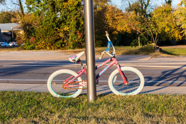 Elkin, N.C., USA-14 October 2022: Worn child's bicycle leaning against post, late sunny day.