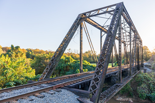 Elkin, N.C., USA-14 October 2022: Steel girder railroad bridge in downtown.  Late afternoon in early autumn.