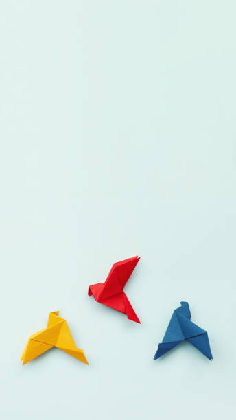 istock three paper origami pigeons red, blue, yellow on light background, vertical, 16 :9, 1438456246