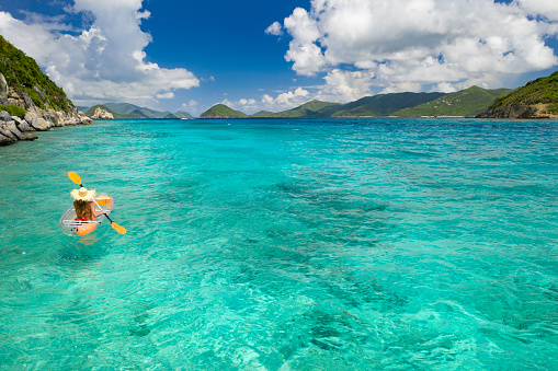 Woman kayaking on clear kayak in tropical water, Congo, Lovango, US virgin islands