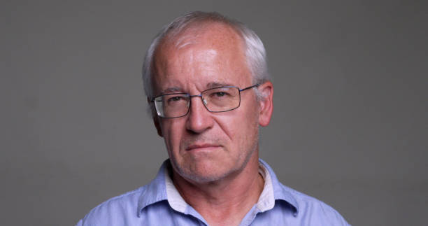 istock Serious man looking at the camera on gray background 1438460473