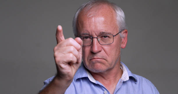 istock Serious, angry man, pointing at you on gray background 1438460481