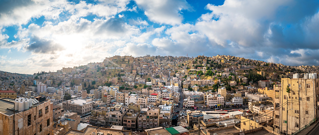 Panoramic view of sunrise over Amman skyline in Jordan. Sunny morning starting above the old downtown of Jordanian capital city built on seven hills from a high altitude on a clear sunny day