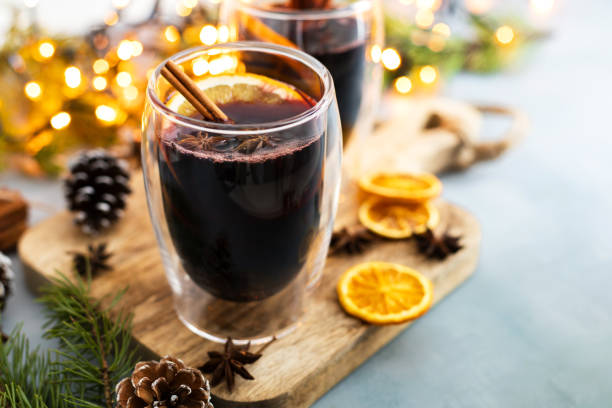 vino caliente fresco caliente en una copa en la mesa junto a las decoraciones de año nuevo - mulled wine punch cocktail christmas fotografías e imágenes de stock
