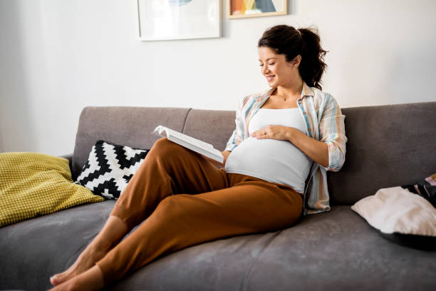istock Pregnant woman reading a book 1438464259