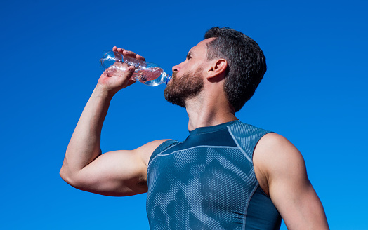 man need hydration. sports and healthy lifestyle routine. water balance in body. athlete feel thirsty after exercise. sportsman drinking from bottle. health care. muscular guy drink water after sport.