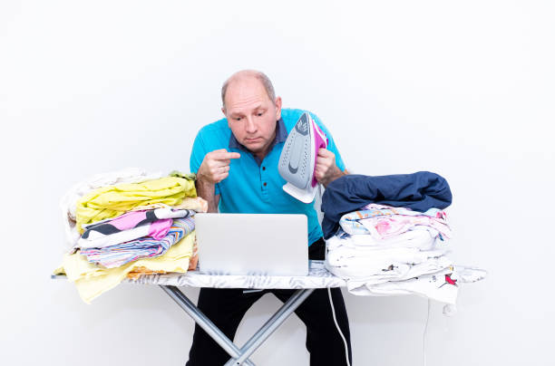 istock Man, Caucasian, householder learn to iron bed linen. 1438466970