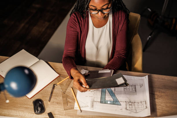 istock Female architect working on a project at her desk late at night 1438468140