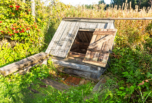 Old wooden water well at the countryside in summer sunny day