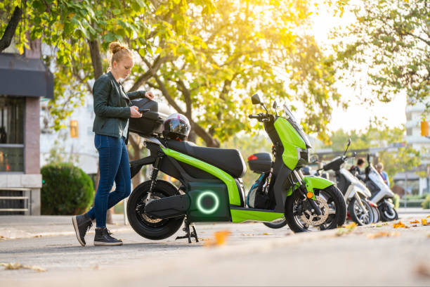 istock Red-haired woman using the smart phone next to her parked motorcycle 1438469926