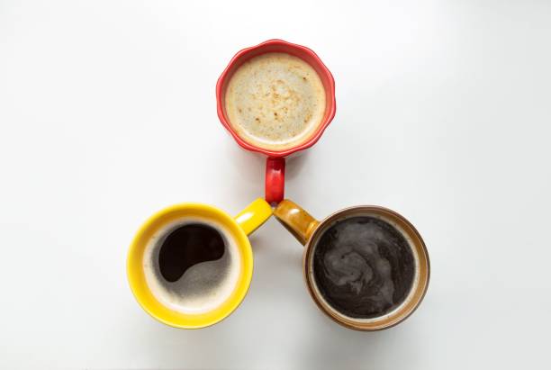 istock Cups of different colors filled with coffee isolated on a white background 1438471966