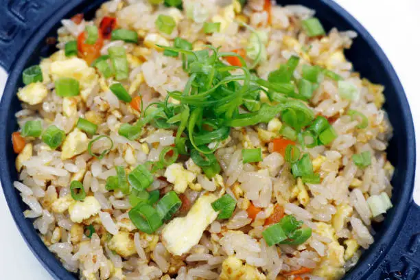 asiatic style chicken,egg and vegetable stir fried rice in close up in a bowl