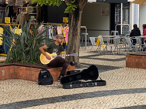 LAGOS,  Portugal - October 20,  2022. People enjoy the performance of street musician in the city of Lagos.