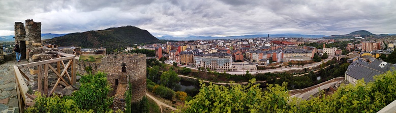 panoramic view of the city from the top of the tower of the medieval castle of the Knights Templar of the 12th century with the hill of the mountain in the background a day with dense and dark clouds, panoramic shooting, Ponferrada, Castilla León, Spain
